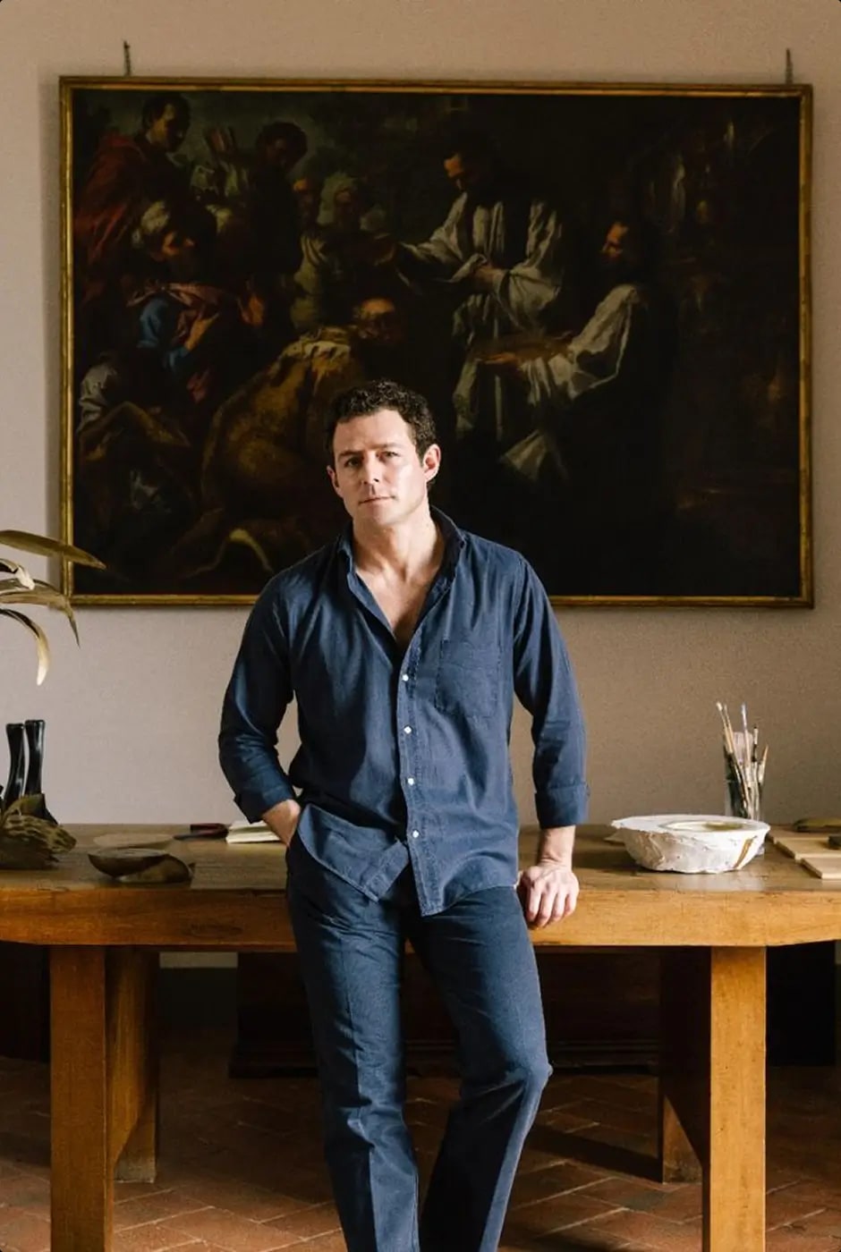 Founder of Maison Rocheval standing in front of a dining table and classical painting
